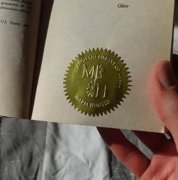 Premium gold foil seal sticker applied inside a book for elegant book decoration and personalized libraries.